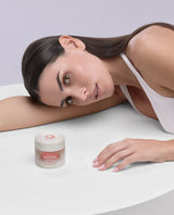 Model resting beside the Lucis Nurturing Day Cream jar — The Nine Aurora daytime hydration.